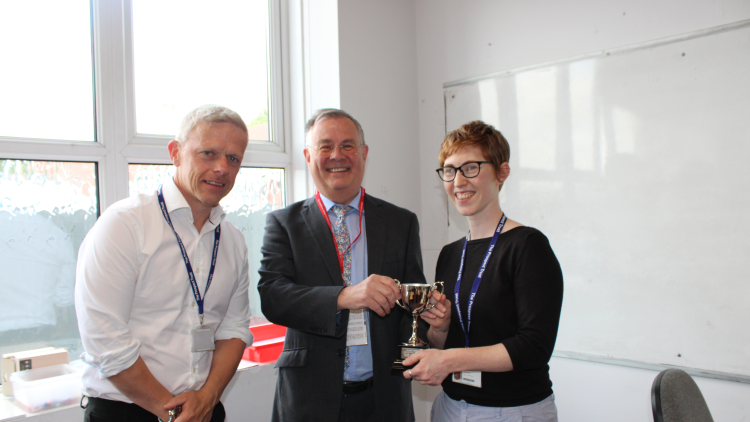<p>Dr Alastair Dougall presents the award to Claire Hayward and Matt Sheppard</p>